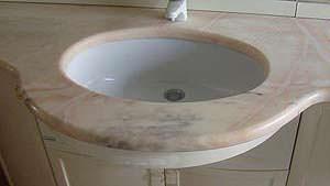 La scelta dei materiali in pietra sintetica: un lavabo ad incasso in un  piano in marmo naturale
